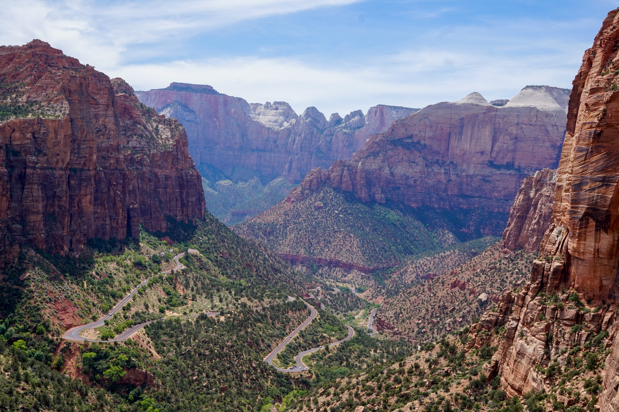 Aerial view of a red rock landscape with a switchback road going through it