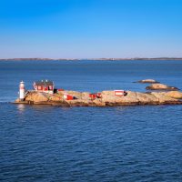 View of a small island with a few red-painted structures in a Swedish archipelago