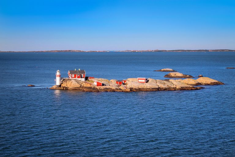 View of a small island with a few red-painted structures in a Swedish archipelago